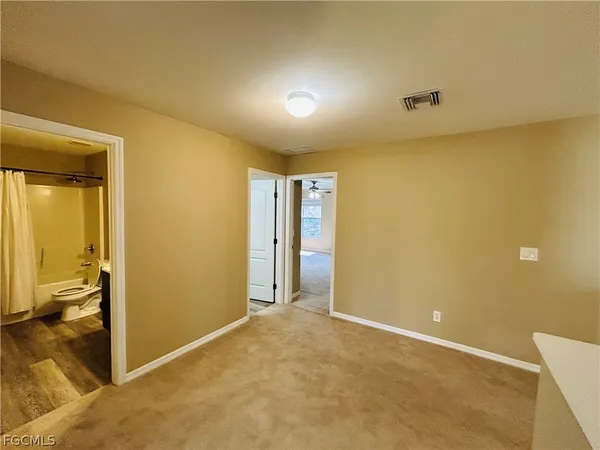 an empty room with a chandeliers fan