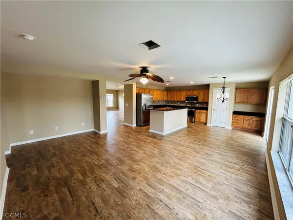 a kitchen with stainless steel appliances kitchen island granite countertop a refrigerator and a stove top oven