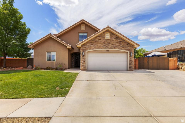 225 Falcon Court Ivins, UT 84738 - Photo 2 of 47 Traditional home with a gate, an attached garage, stucco siding, concrete driveway, and stone siding