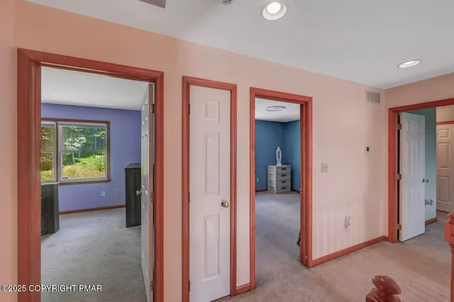 a view of a hallway with a livingroom and a bathroom