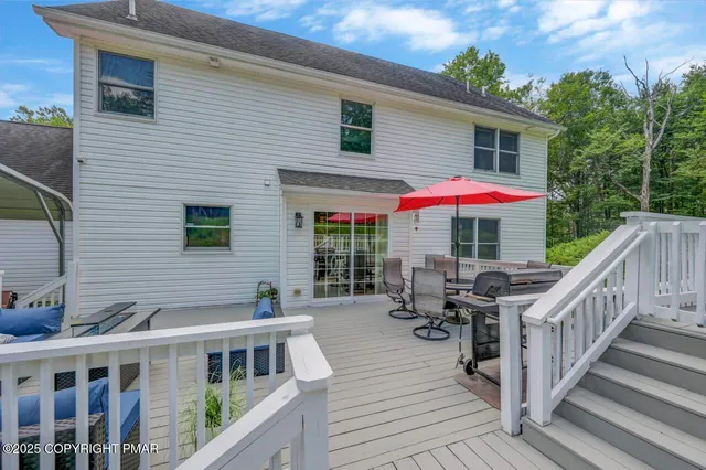 a view of a house with a deck and furniture