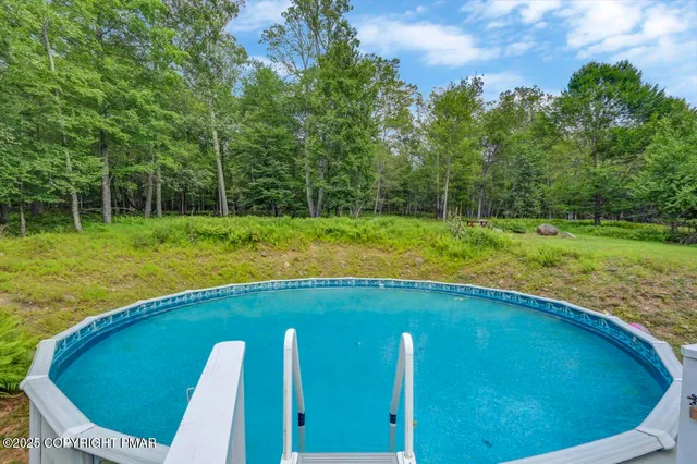 a view of a backyard with swimming pool