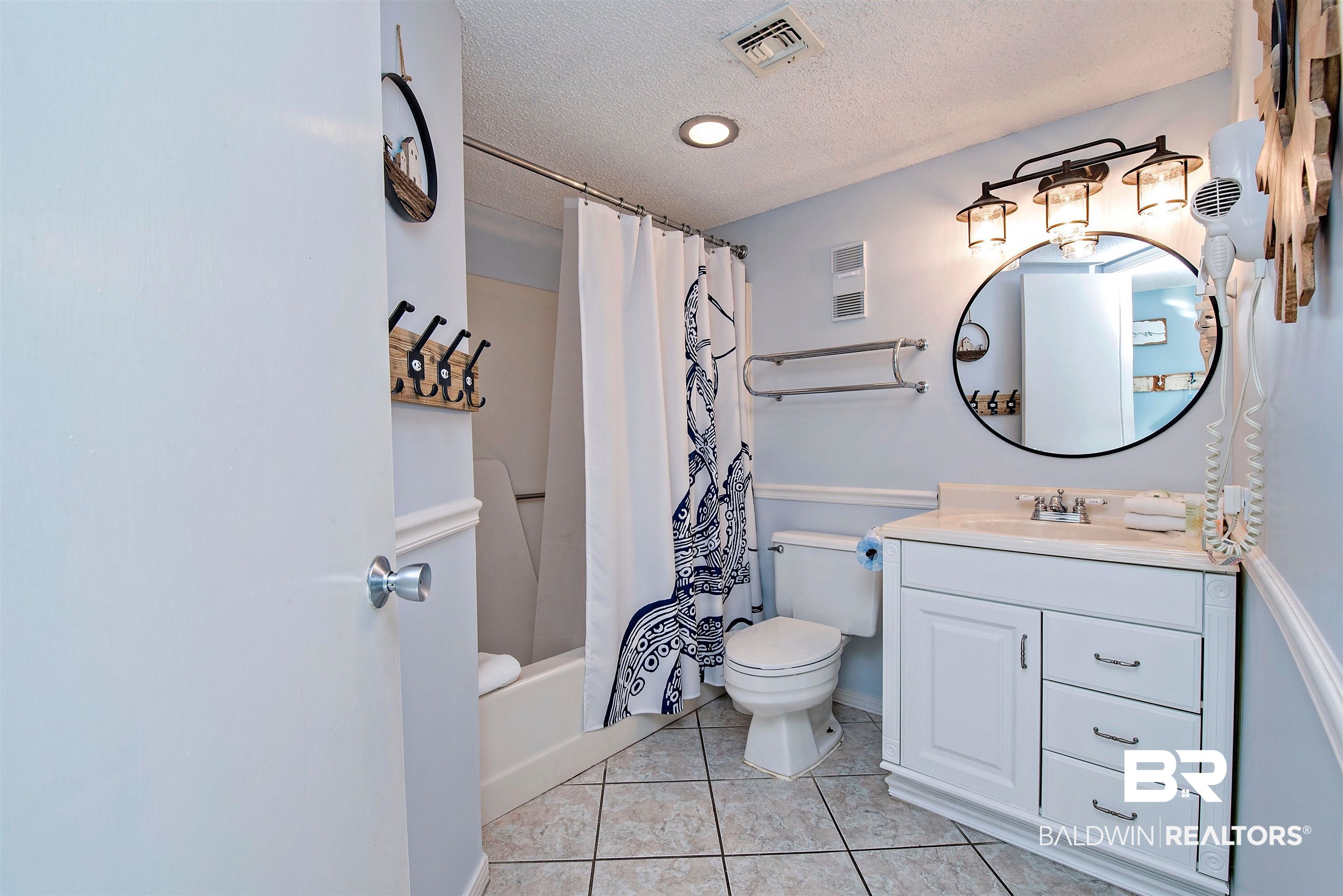 497 Plantation Road, Unit 1156 Gulf Shores, AL 36542 - Photo 20 of 28 Full bathroom with a textured ceiling, vanity, toilet, shower / bathtub combination with curtain, and tile patterned floors