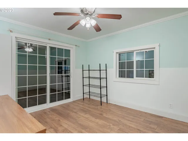 a view of empty room with windows and ceiling fan
