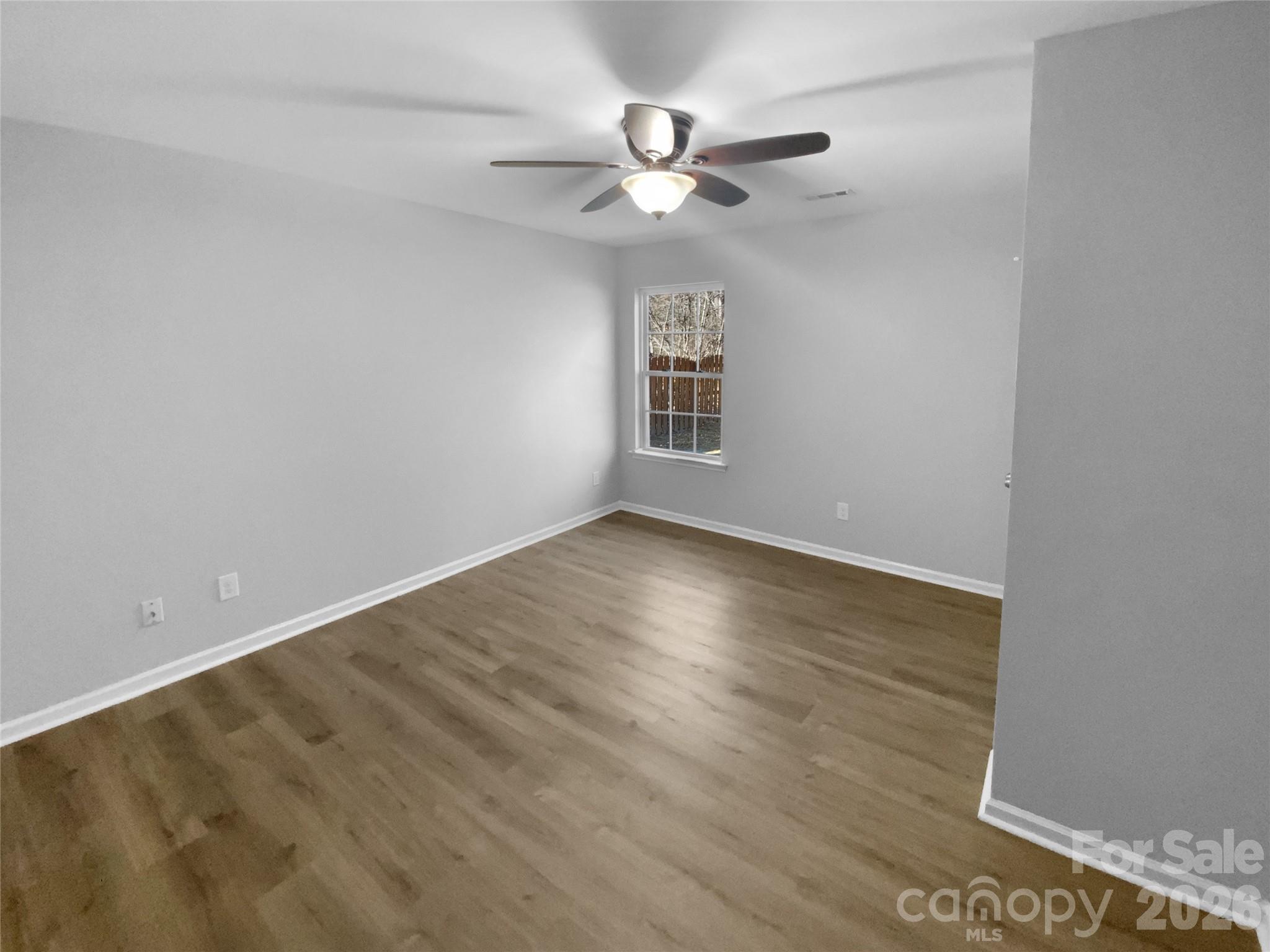 4115 Granite Street Midland, NC 28107 - Photo 18 of 25 an empty room with wooden floor chandelier fan and windows