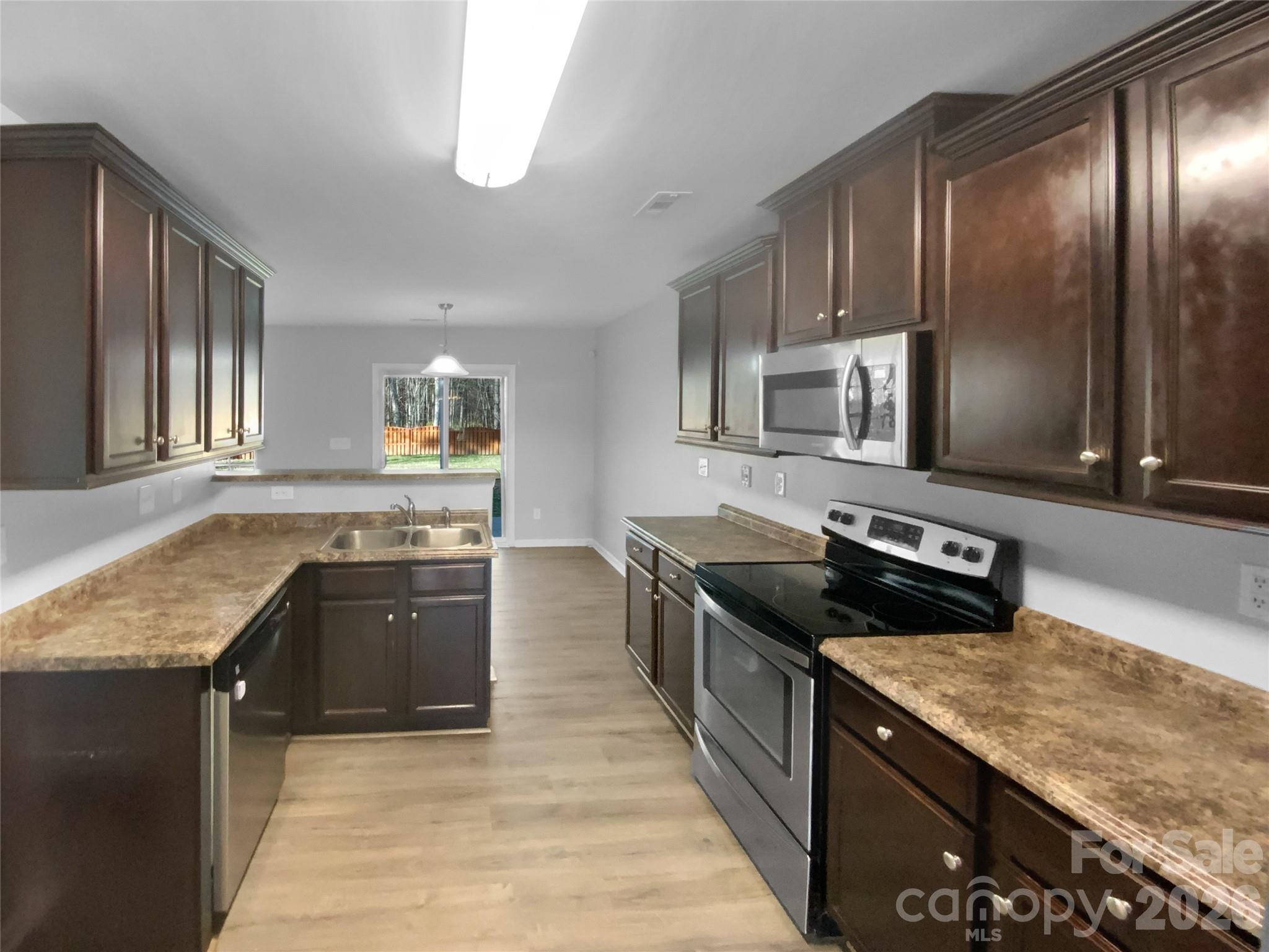 4115 Granite Street Midland, NC 28107 - Photo 2 of 25 a kitchen with granite countertop stainless steel appliances and wooden cabinets