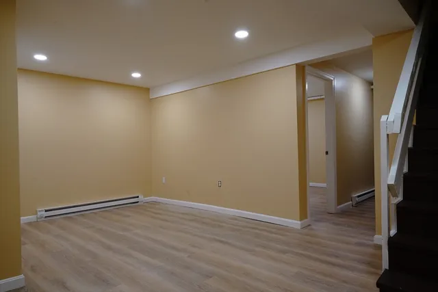 an empty room with wooden floor and entrance