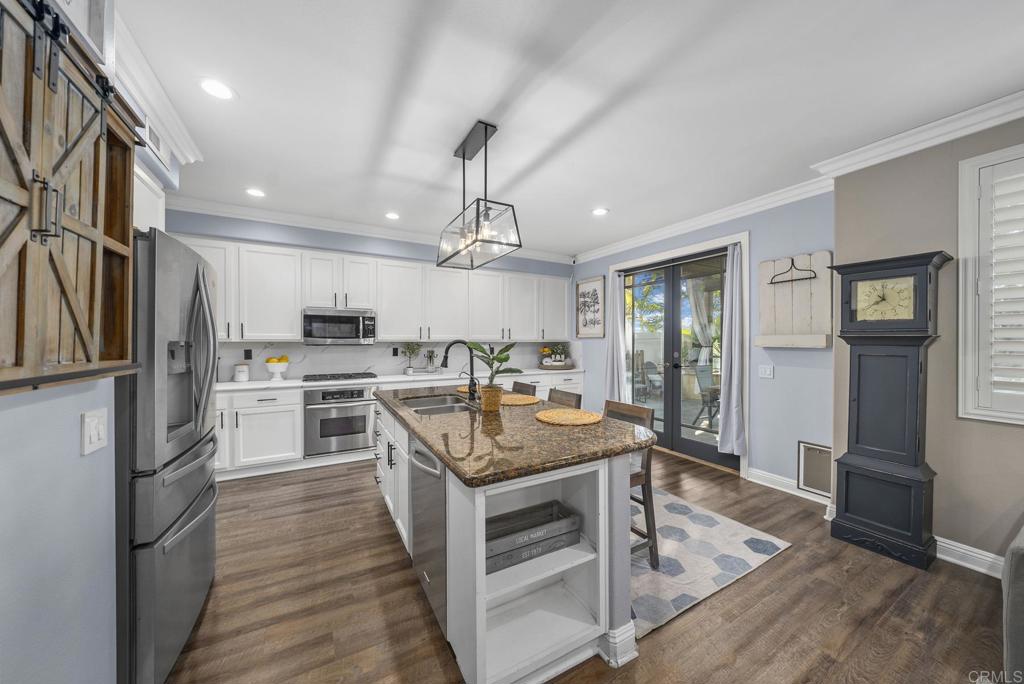 23 Wayfaire Rancho Santa Margarita, CA 92688 - Photo 13 of 44 a kitchen with a center island wooden floor and stainless steel appliances
