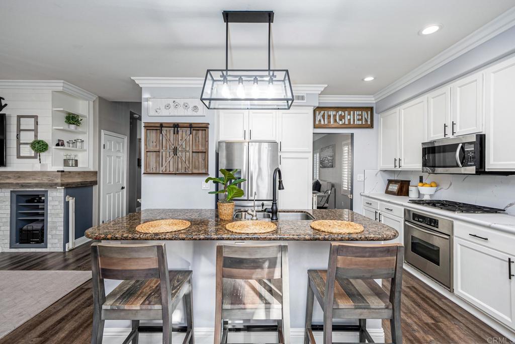 23 Wayfaire Rancho Santa Margarita, CA 92688 - Photo 5 of 44 a kitchen with stainless steel appliances granite countertop a stove a kitchen island a dining table and chairs