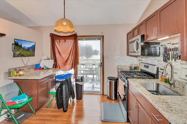 a kitchen with stainless steel appliances granite countertop a stove a sink and a microwave