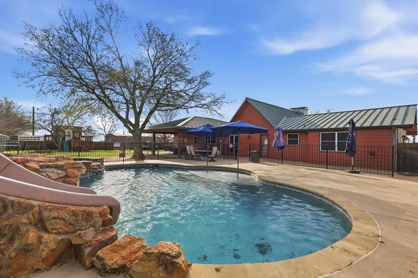 a view of a house with swimming pool next to a yard