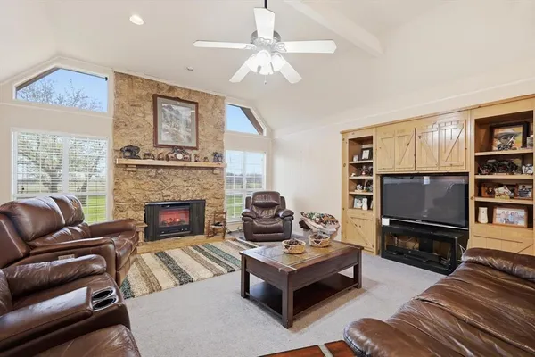 a living room with furniture a flat screen tv and a fireplace