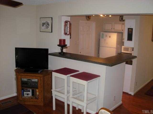 3905 Olde Coach Road Durham, NC 27707 - Photo 6 of 12 a kitchen with stainless steel appliances a stove and a flat screen tv