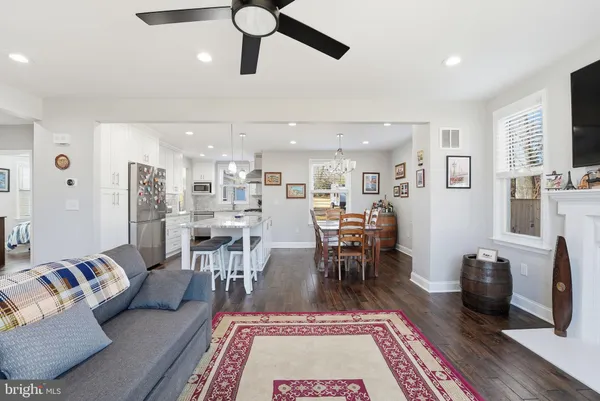 a living room with furniture a rug and a dining table