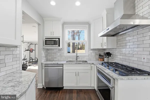 a kitchen with cabinets appliances a sink and a counter top space