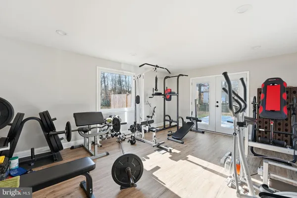 a living room with furniture a flat screen tv and gym equipment