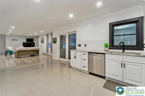 a kitchen with white cabinets stainless steel appliances and a window