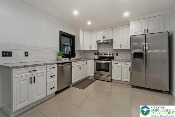 a kitchen with white cabinets and white appliances