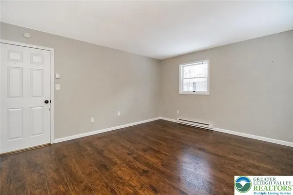 a view of an empty room with wooden floor