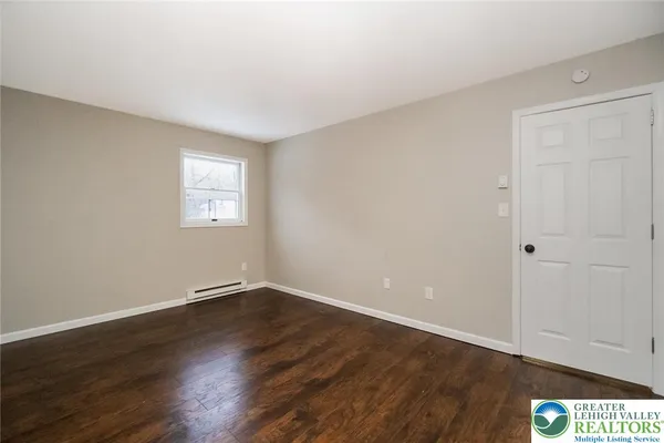 a view of an empty room with wooden floor