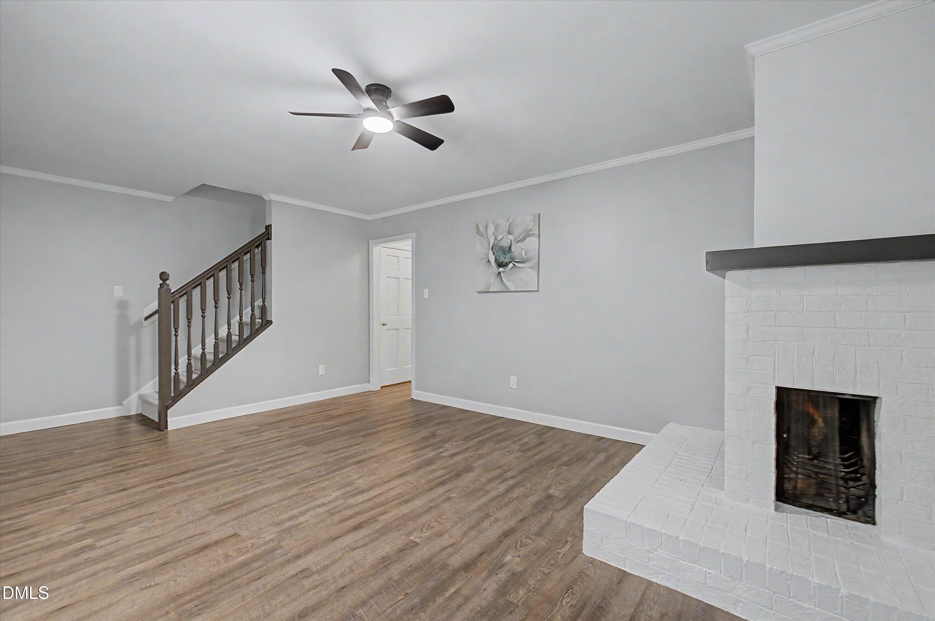 5519 Hamstead Crossing Raleigh, NC 27612 - Photo 5 of 33 a view of an empty room with wooden floor and a ceiling fan