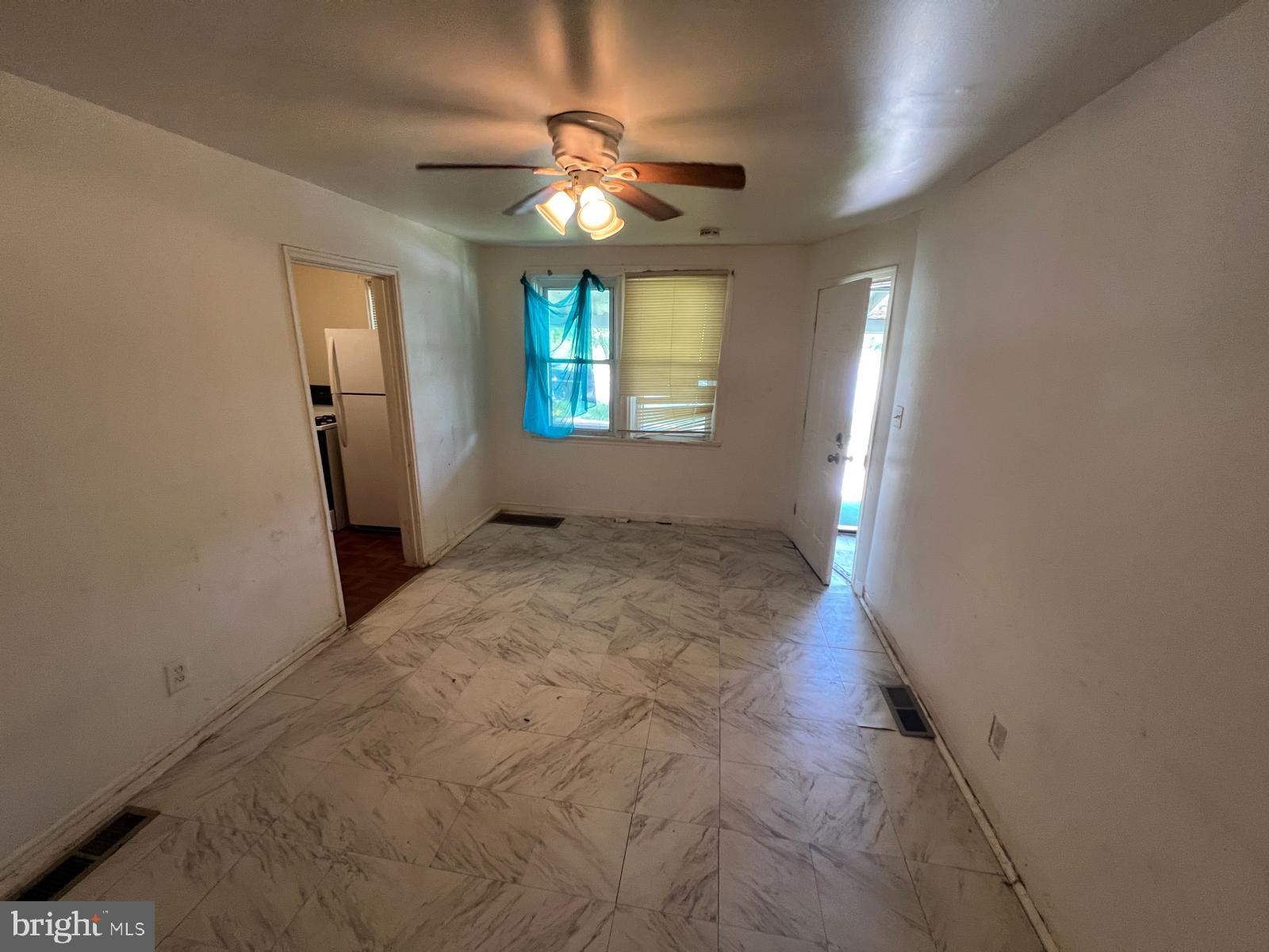 313 Cherry Hill Road Baltimore, MD 21225 - Photo 12 of 16 en empty room with windows and chandelier fan