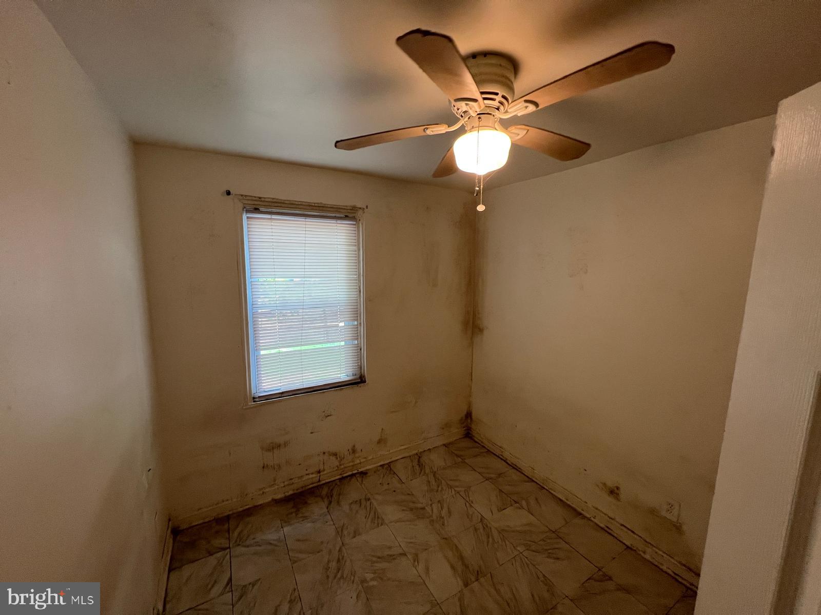 313 Cherry Hill Road Baltimore, MD 21225 - Photo 7 of 16 an empty room with a window and a fan