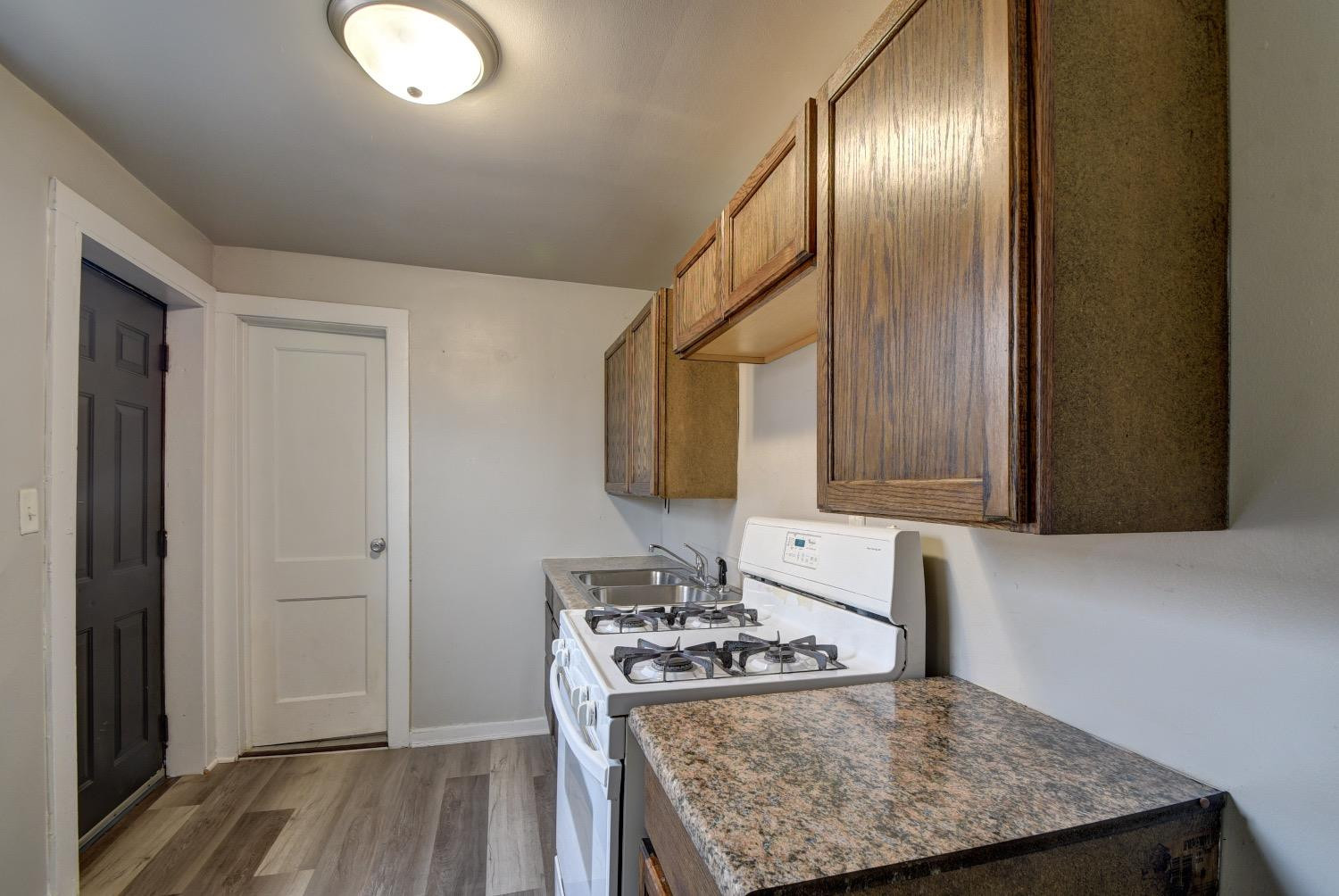3044 West Ridge Road, Unit RD Gary, IN 46408 - Photo 7 of 13 a kitchen with cabinets and wooden floor