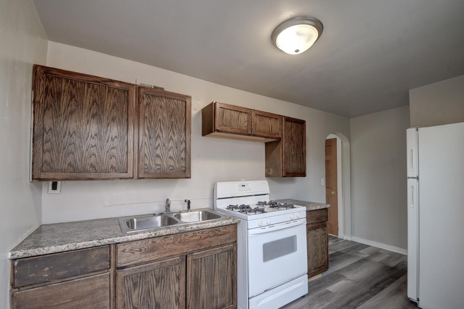 3044 West Ridge Road, Unit RD Gary, IN 46408 - Photo 8 of 13 a kitchen with stainless steel appliances granite countertop a stove a sink and a refrigerator with wooden cabinets