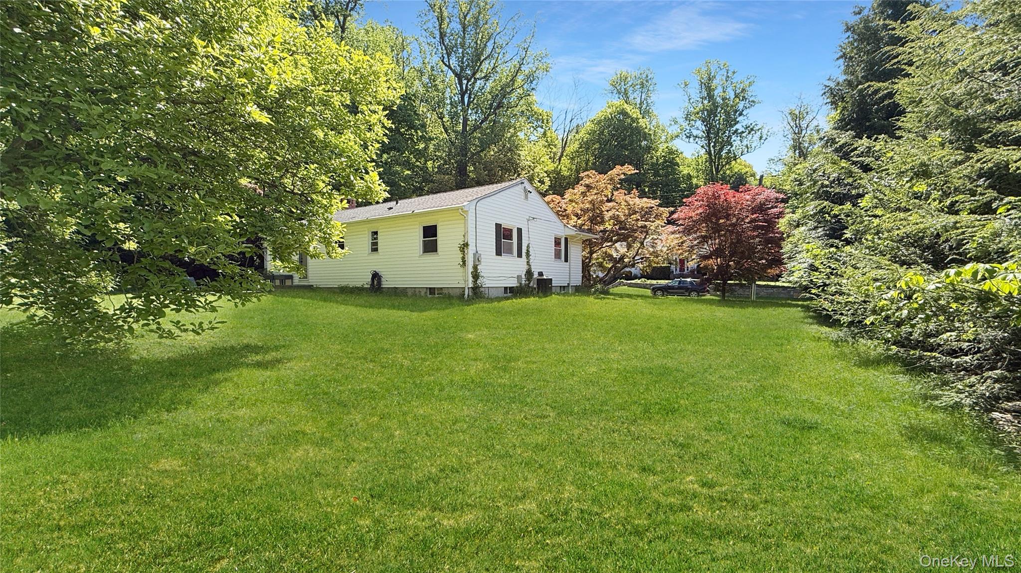15 Whitehill Place Cold Spring, NY 10516 - Photo 10 of 12 a house that is sitting in the grass with large trees and plants