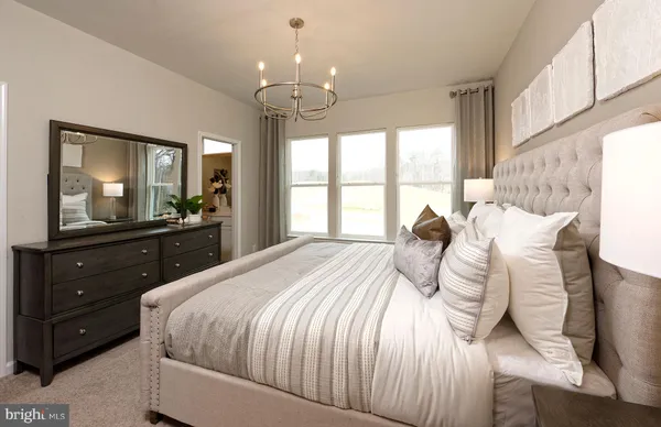 a bedroom with a bed and a large mirror on the dresser