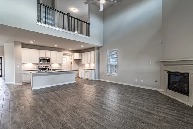 a large kitchen with cabinets wooden floor and a fireplace