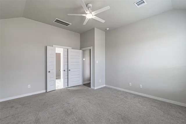 an empty room with closet and a ceiling fan