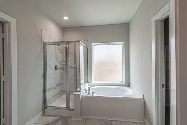 a bathroom with a tub shower and sink