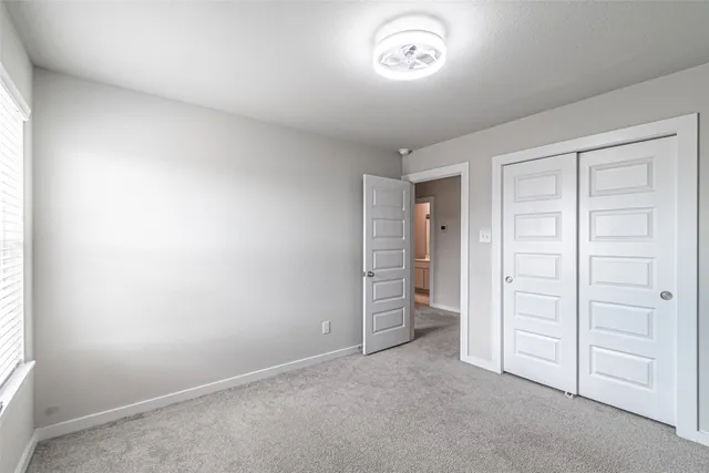 an empty room with closet and a window
