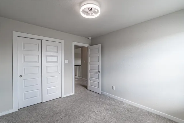 an empty room with closet and a window