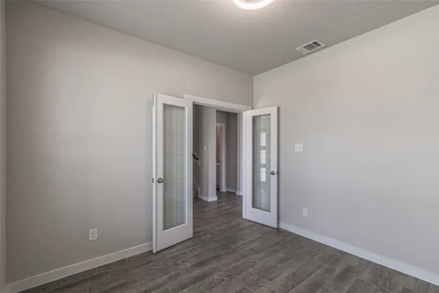 a view of an empty room with wooden floor