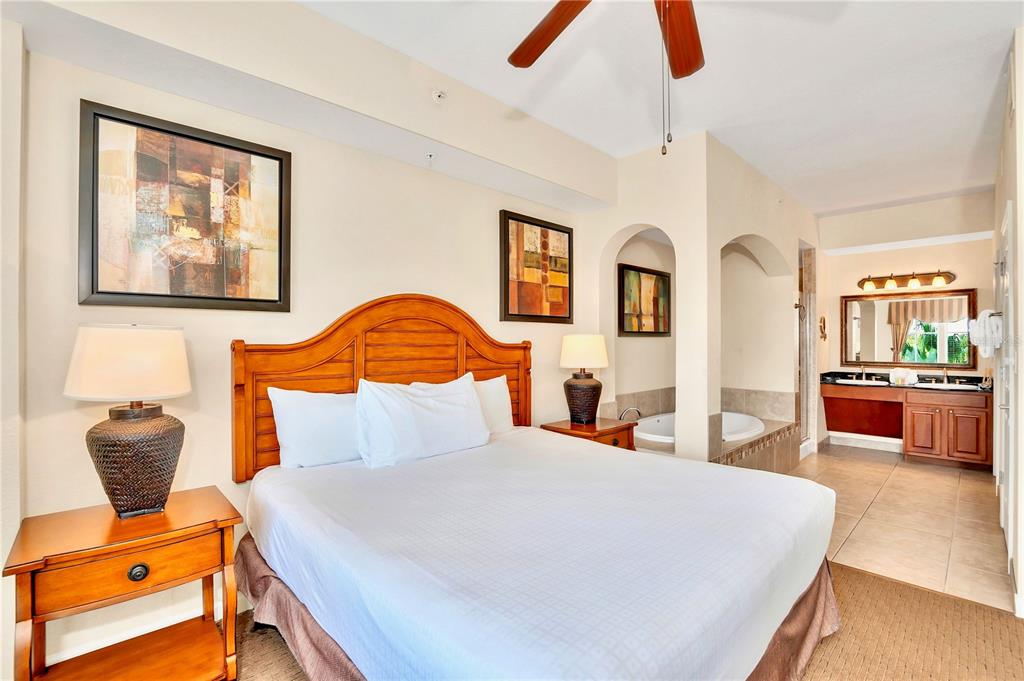 8113 Resort Village Drive, Unit 4405 Orlando, FL 32821 - Photo 14 of 25 a bedroom with a bed and wooden floor
