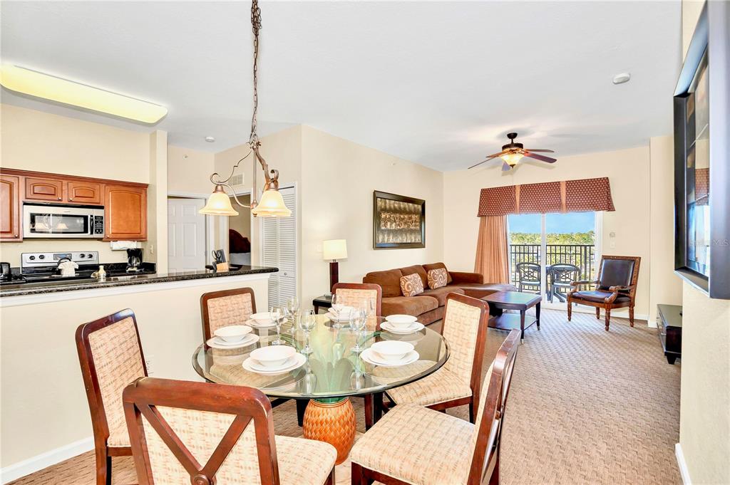 8113 Resort Village Drive, Unit 4405 Orlando, FL 32821 - Photo 4 of 25 a dining room with furniture a rug and wooden floor