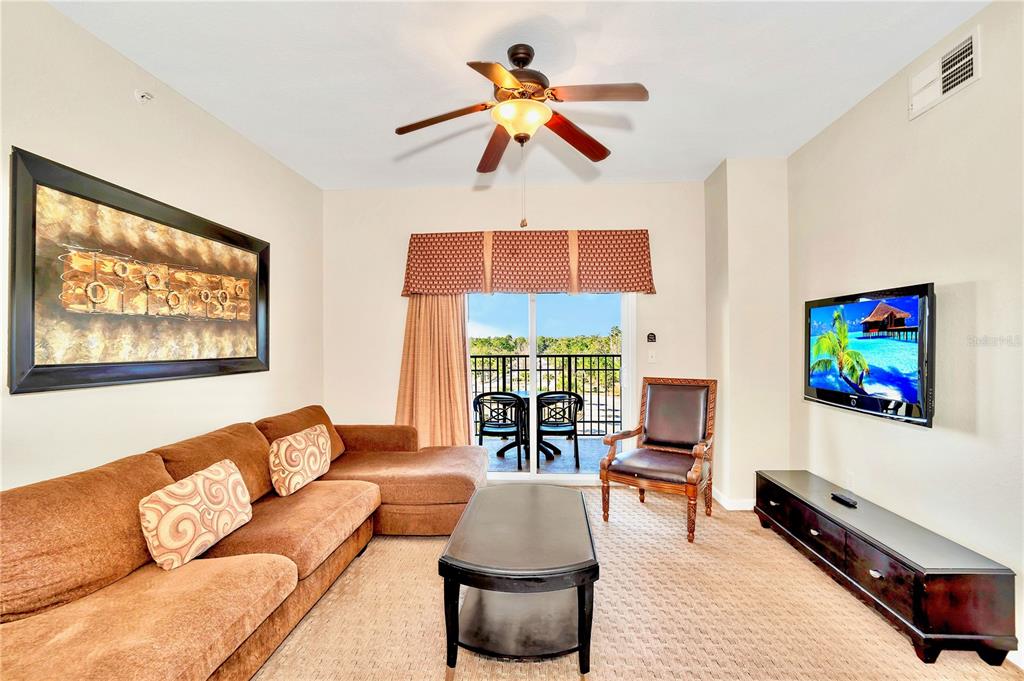 8113 Resort Village Drive, Unit 4405 Orlando, FL 32821 - Photo 8 of 25 a living room with furniture fireplace and flat screen tv