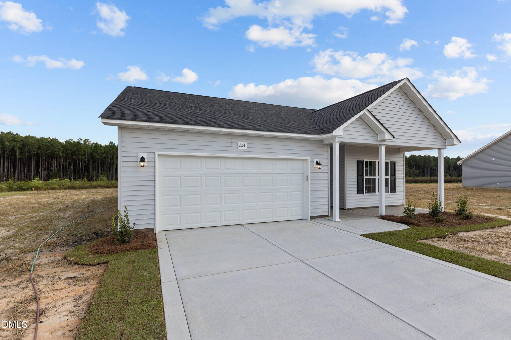 506 Bill Avery Road Coats, NC 27521 - Photo 4 of 21 a front view of a house with a yard and garage