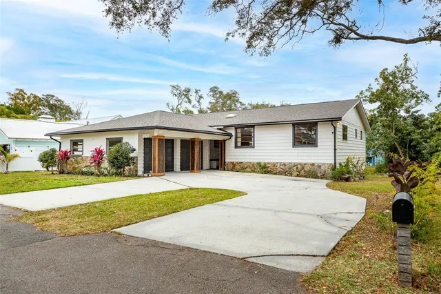 front view of house with a yard and potted plants
