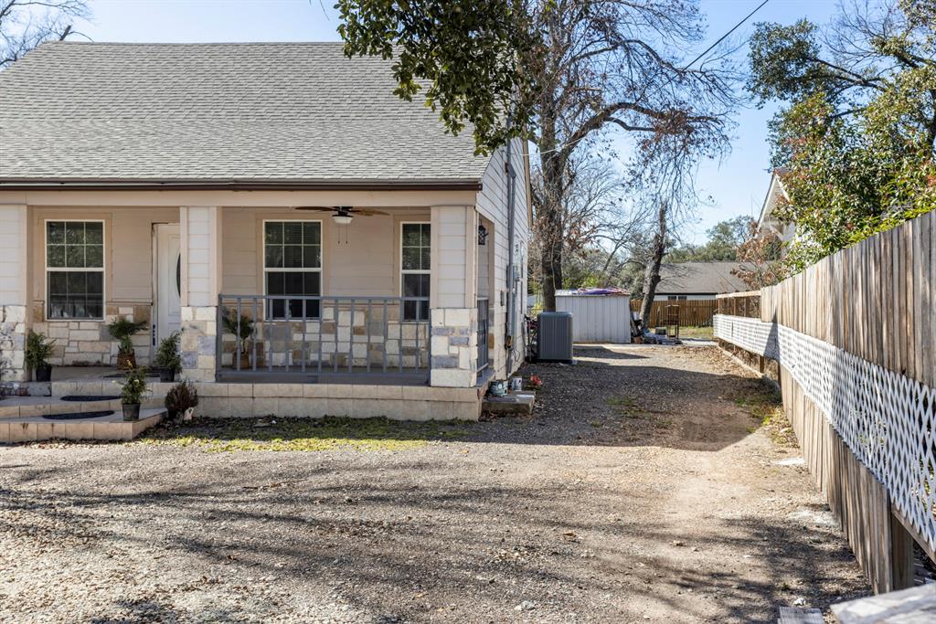 811 Ward Street Marlin, TX 76661 - Photo 31 of 31 View of front of property with a shingled roof, covered porch, ceiling fan, gravel driveway, and stone siding