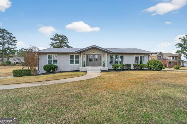 a view of a house with a swimming pool and a yard