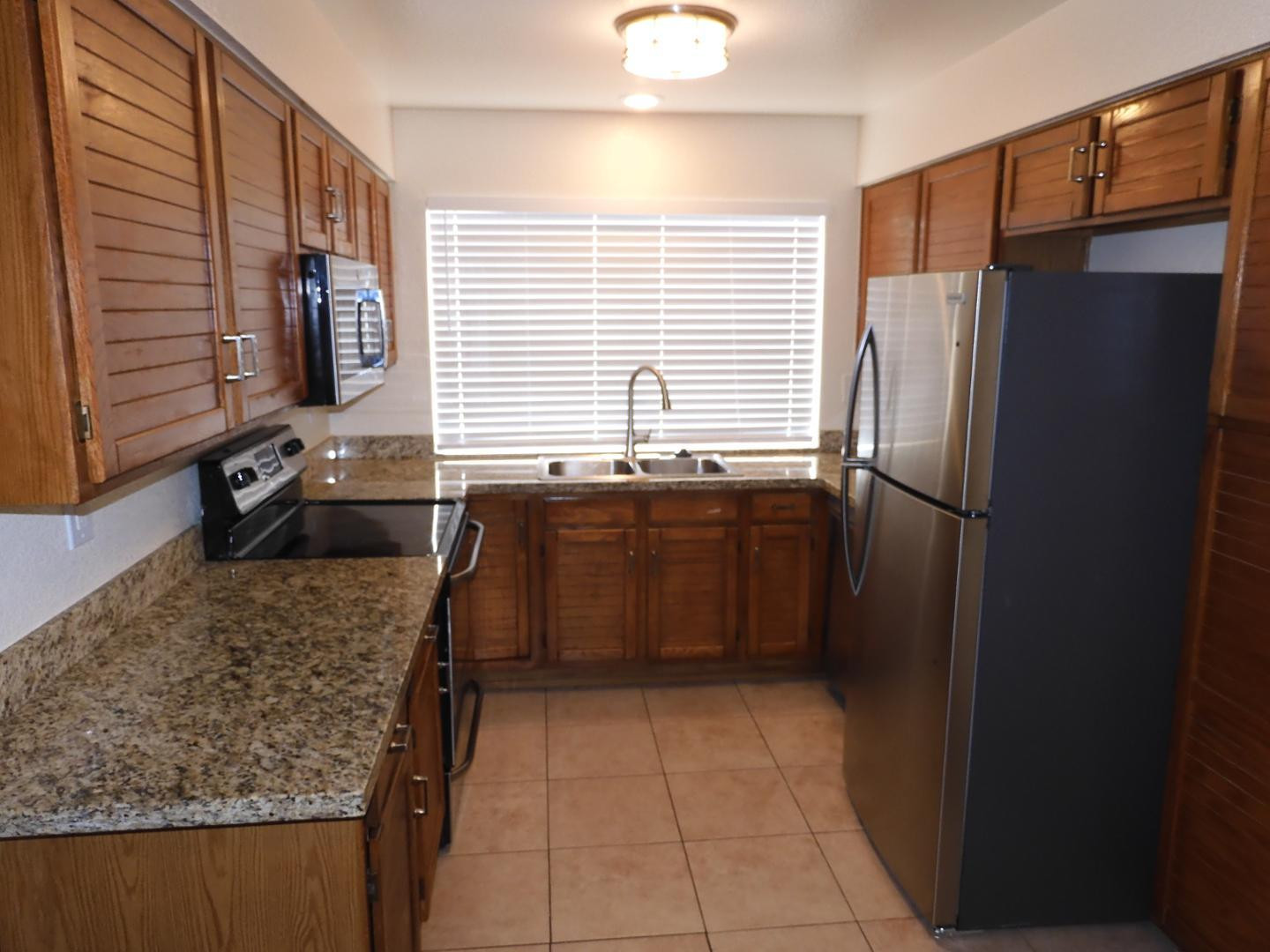 154 West 5th Street, Unit 233 Tempe, AZ 85281 - Photo 9 of 29 a kitchen with stainless steel appliances granite countertop a refrigerator and a sink