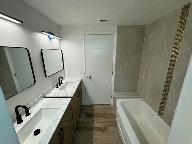 a bathroom with a tub sink and mirror