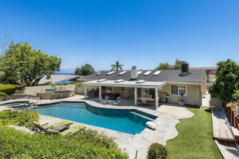 an aerial view of a house with swimming pool garden and patio