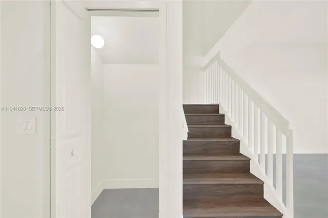 a view of staircase with lots of frames on wall and wooden floor