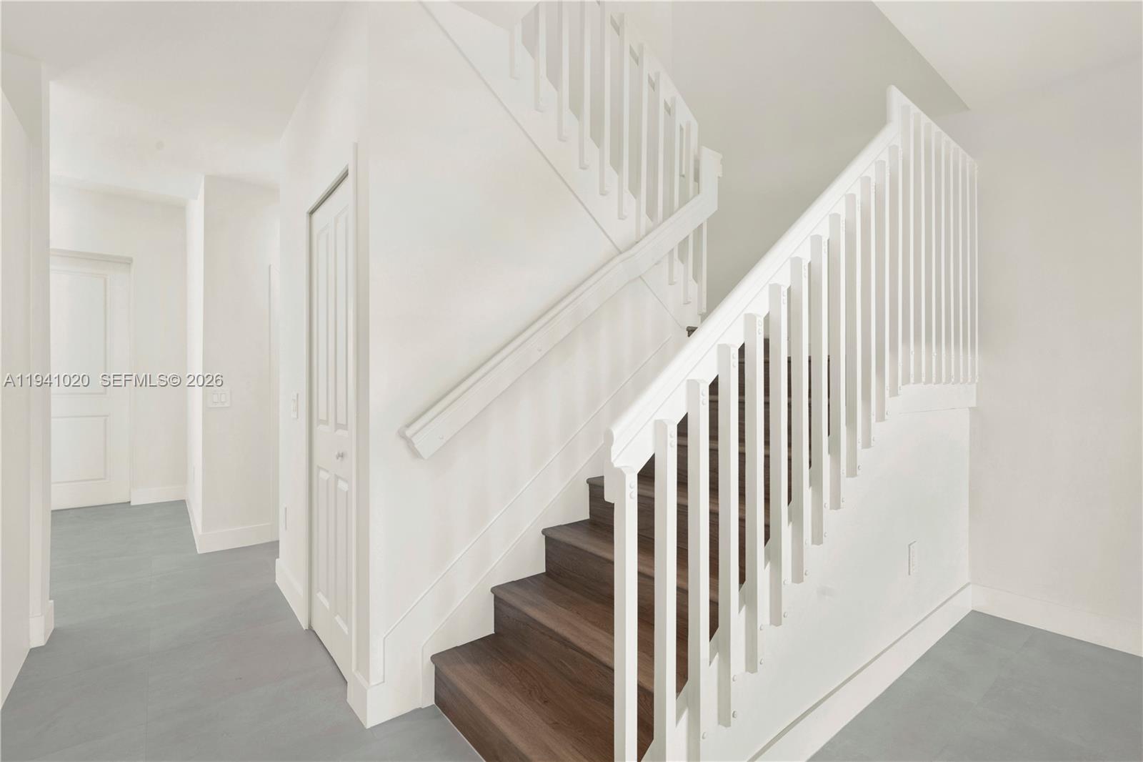 18981 Southwest 344th Terrace, Unit 18981 Homestead, FL 33034 - Photo 18 of 34 a view of staircase with lots of frames on wall and wooden floor