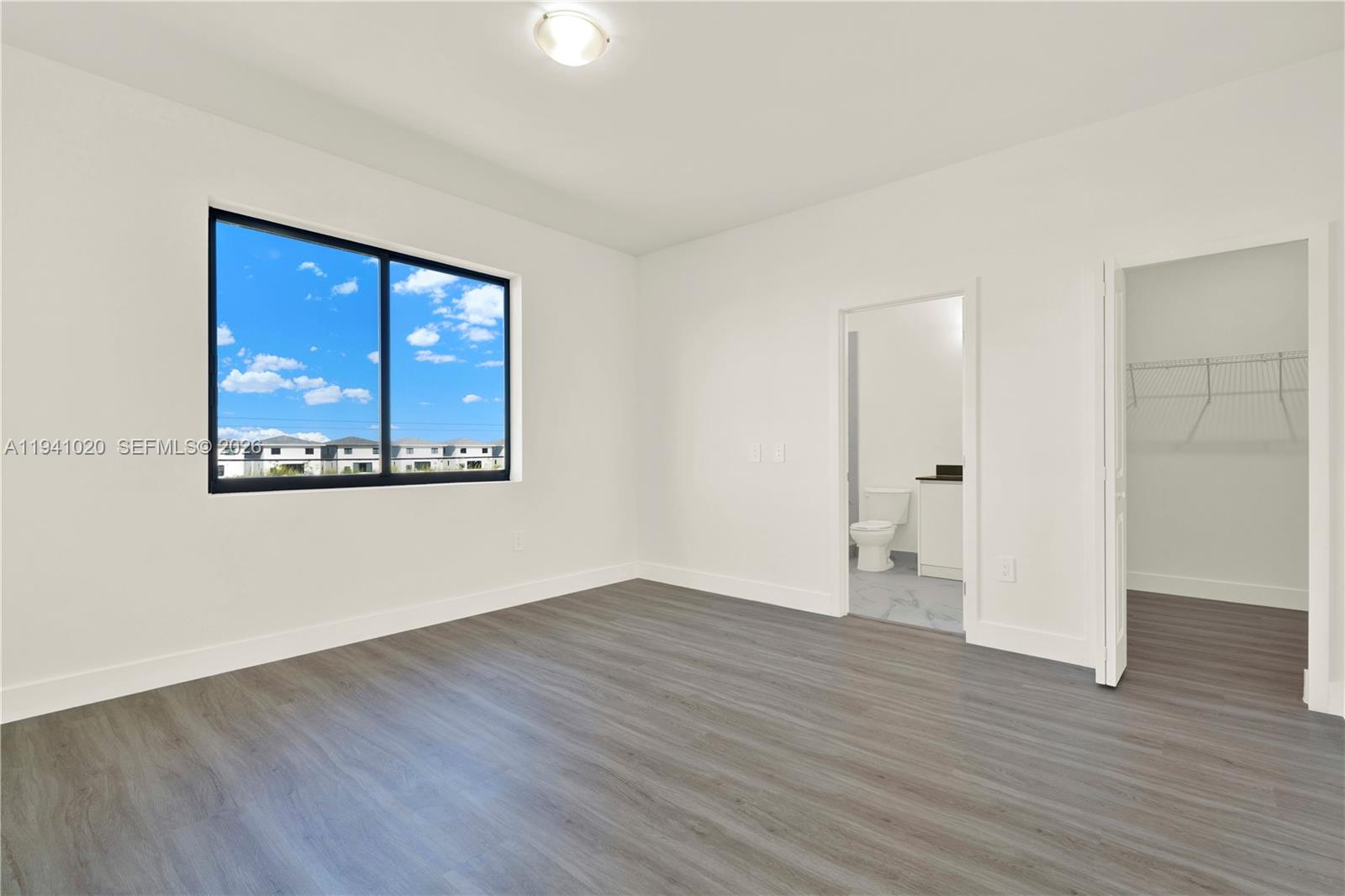 18981 Southwest 344th Terrace, Unit 18981 Homestead, FL 33034 - Photo 22 of 34 an empty room with wooden floor and windows